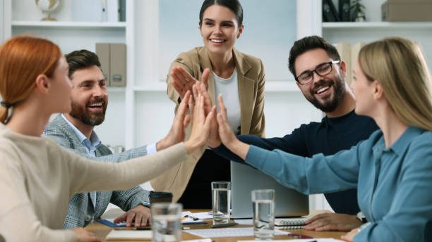 Team of employees joining hands in office Team of employees joining hands in office